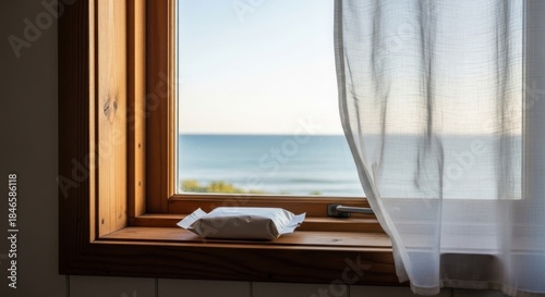 Wet wipes package mockup on a wooden windowsill with a beautiful sea view.