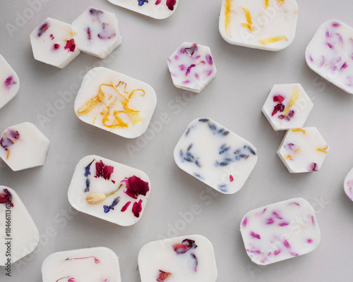 handmade wax sachets with embedded dried flowers on a light gray background. Ideal for illustrating home fragrance, aromatherapy, or DIY craft projects.
