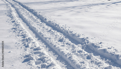 Parallel tracks in fresh snow under bright sunlight, In What Style: Minimalist nature photography with high contrast, In What Colors: Pure white and soft blue shadows against crisp winter light, What 