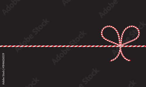 Red and White String Rope with Crossed Bow Isolated on black background. symbolizing gift wrapping, holidays, celebration, and handmade packaging on black  background.