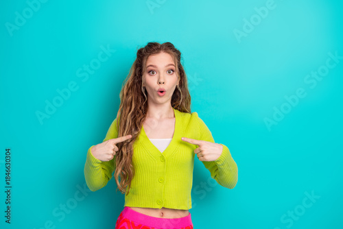 Fotografi Young woman expressing surprise while pointing at herself against a turquoise ba