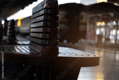 Train station bench wooden seat empty platform low light travel vintage style urban morning reflective floor waiting area filled with quiet mood and gentle light