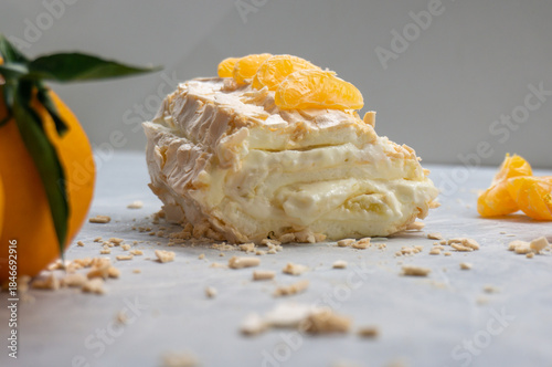 Meringue roll with cream and tangerines. Close-up.