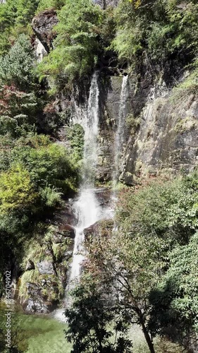 Melting glacier, waterfall from top of the mountain, view on the water flow, green valley, at the foot of the Himalayan mountain range.