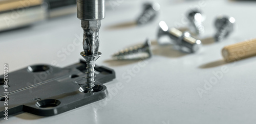 Quadro em tela Furniture assembly. Closeup of screwing a screw in MDF material