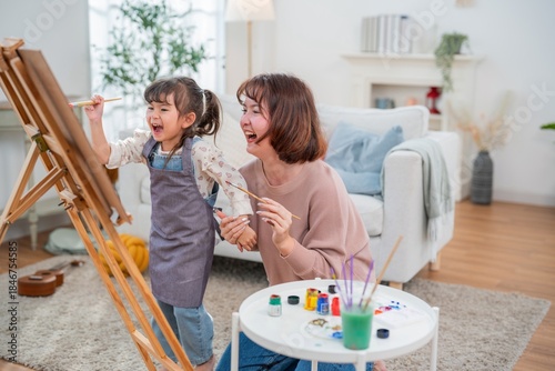 Slika na platnu Mom and daughter spend time painting together in a bright living room on a weeke