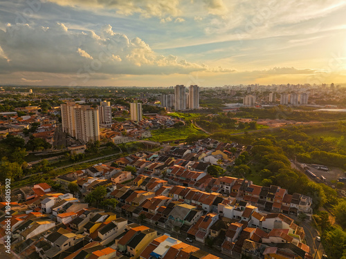 aerial view of green area in the middle of the city in the countryside of Sao Paulo state during sunset with blue and yellow sky