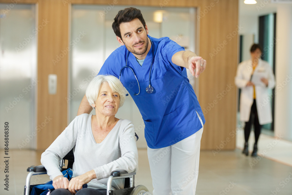 Obraz premium male nurse looking at senior woman in wheelchair