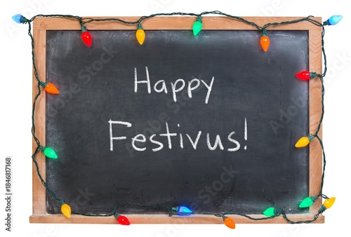 Happy Festivus handwritten in white chalk on a black chalkboard decorated with festive holiday lights isolated on white