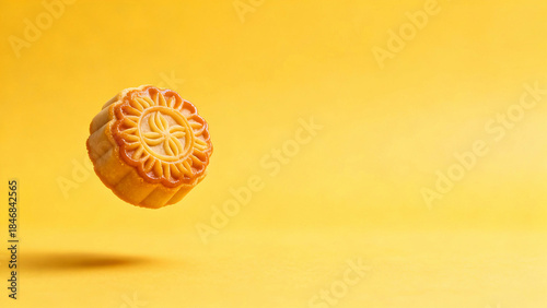 Traditional Chinese Mooncake Levitating on Vibrant Yellow Background