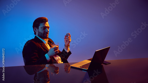 Canvas-taulu Man analyzing casino token with drink during online gambling session