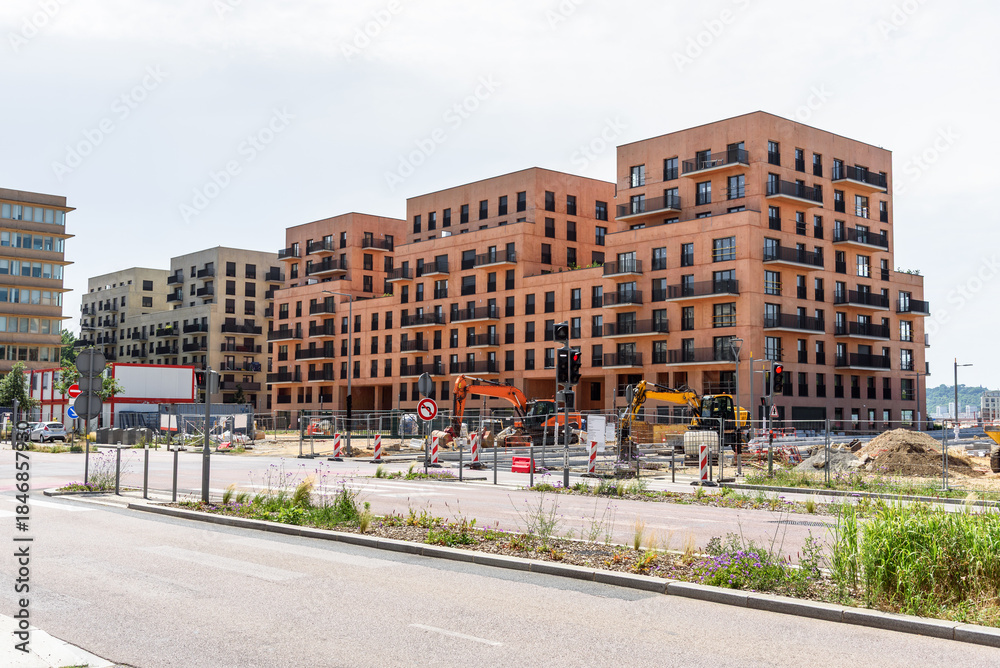 Fototapeta premium Apartment buildings under construction in a new development in a urban setting on a sunny summer day