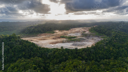 Mines in nusakambangan quarry surrounded by dense forest under a peaceful cloudy sky, great for environmental or industrial concepts.