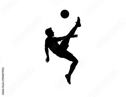 A silhouette of a soccer player kicking in an acrobatic position 