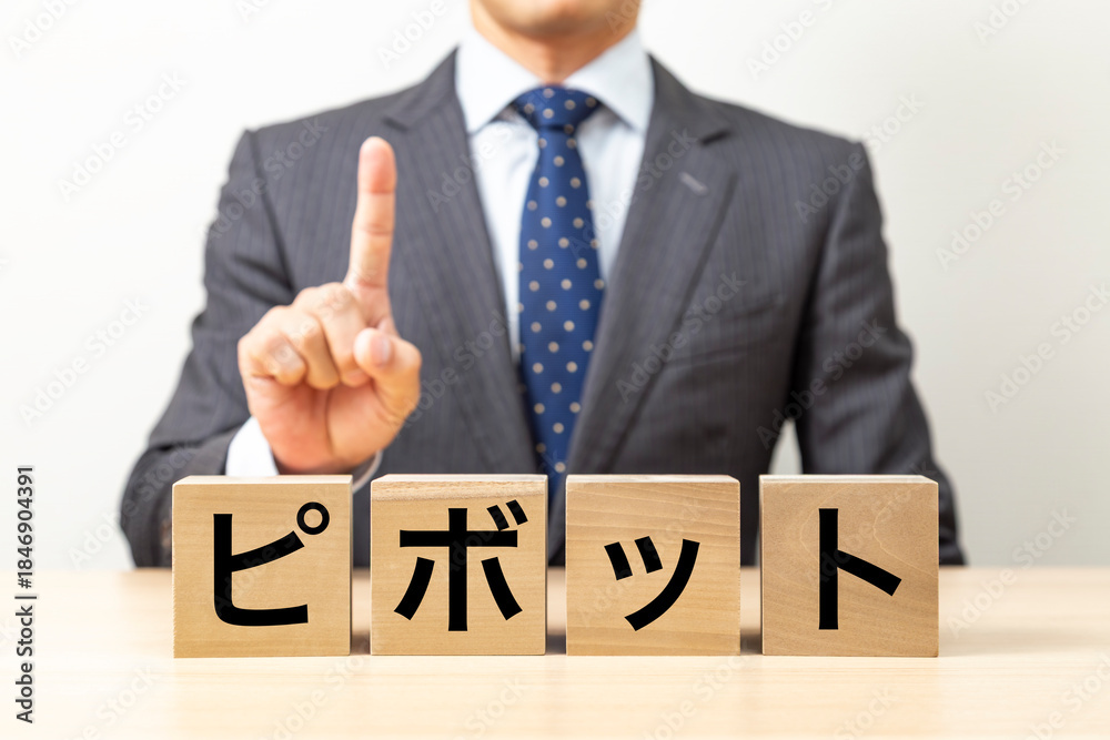 Obraz premium 「ピボット」と書かれたブロックとビジネスマン