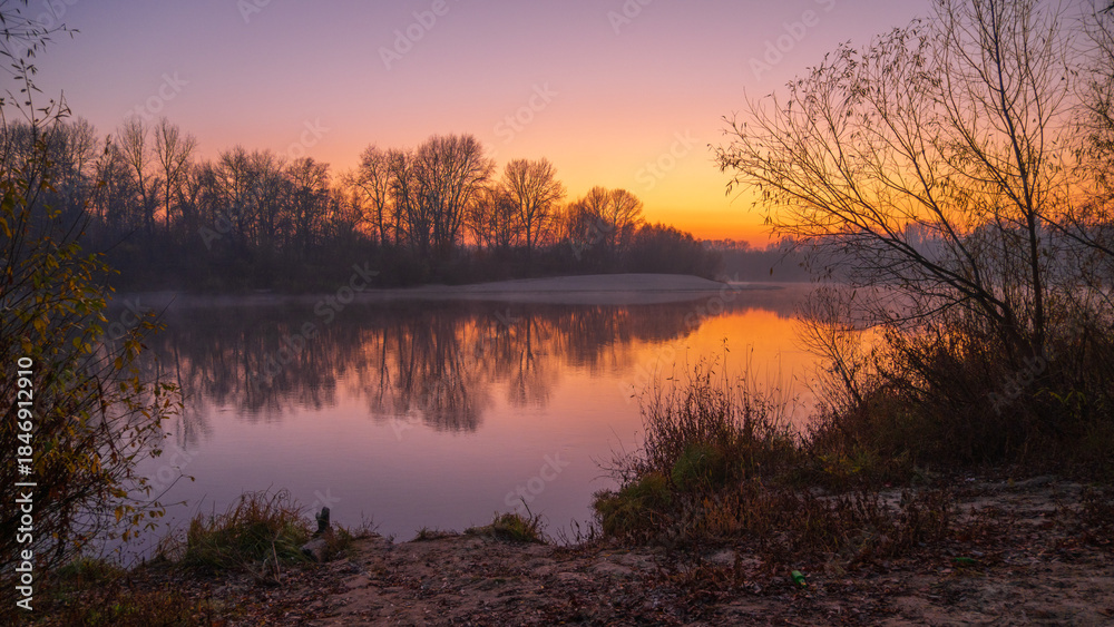 Fototapeta premium autumn foggy sunrise on the river around forest
