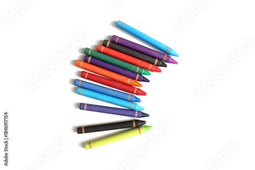 There are many multi-colored wax crayons lying on a white background.