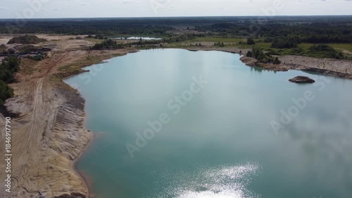 Artificial lake among waste rock dumps in quarry, aerial view