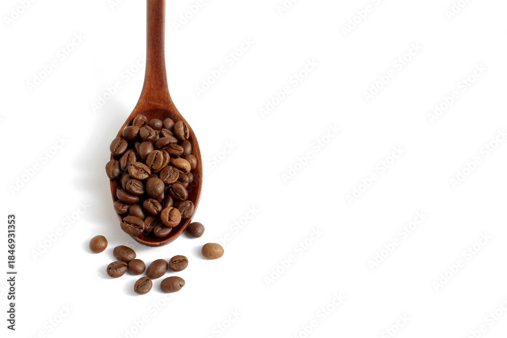 Obraz premium On a white background lies a wooden spoon with coffee beans.