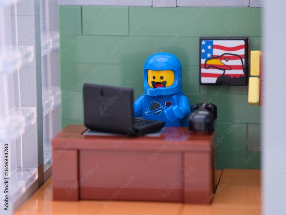 Obraz premium Tambov, Russian Federation - May 26, 2025 Lego Benny cosmonaut minifigure working behind a laptop on his workplace at the office