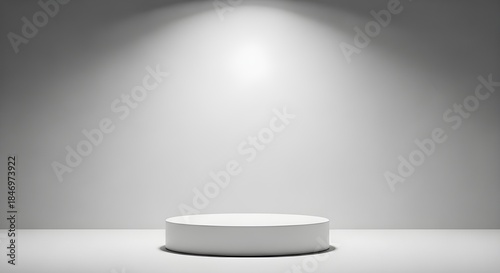A solitary white cylinder pedestal in a spotlight