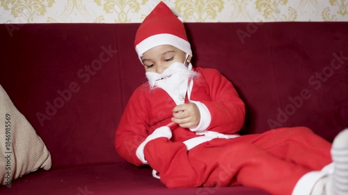 joyful christmas moment with kid dressed as santa and picking out gifts at indoors