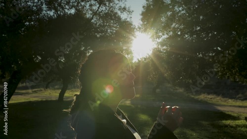 Pregnant woman like a slice of ham with the sun in the background in a meadow in sprin