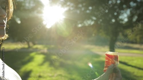 Mujer embarazada come jamón ibérico al atardecer en plena naturaleza