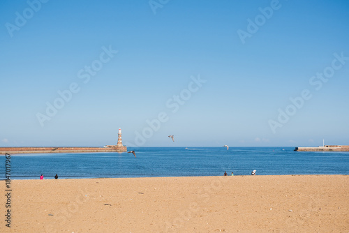 Sunderland UK: 16th July 2025: sandy Roker Beach in Sunderland. The sun shines brightly and boats can be seen on the water. A lighthouse stands in the distance.
