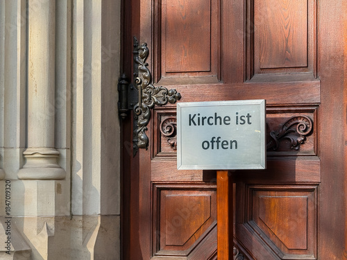 Church is open german text near wooden door