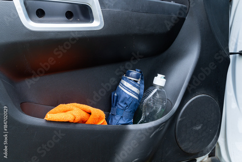 Car door pocket with umbrella, microfiber cloth, and pump bottle.