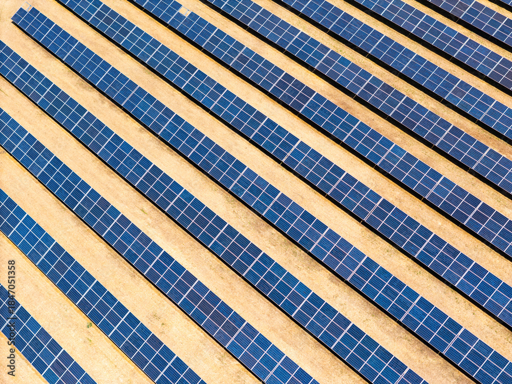 Naklejka premium Photovoltaic arrays across vineyard rows in the Italian countryside, aerial drone view. Renewable electricity for low-carbon power and grid decarbonization