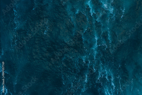 Aerial top down view of Atlantic oceanic waves rolling and creating foam patterns, Drone filming breaking surf with foam in Atlantic ocean