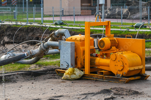 Industrial dewatering pump with hoses operating at construction site for groundwater removal