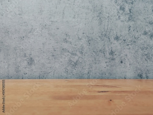 Empty Concrete Wall and Wooden Table Surface Abstract Background. Minimalist empty background with rough gray concrete wall and warm wooden table top. Perfect for product display, mockup or presentati