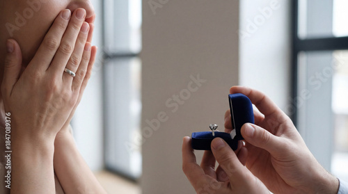 Man offers ring box, woman surprised. Closeup hands hold ring, diamond ring shines near window, perfect for engagement, valentines greeting, wedding announcement, romantic lifestyle concept