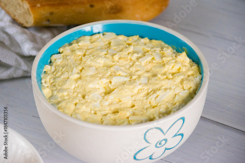 Appetizing and spicy salad with egg and processed cheese in a salad bowl.