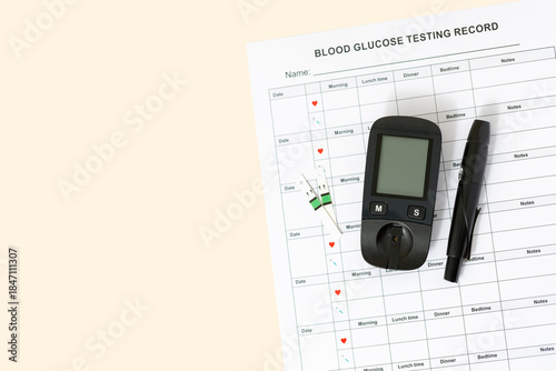 Top view of glucometer, lancet pen, strips and blood sugar tracker and diary sheet on beige background. Diabetes test kit