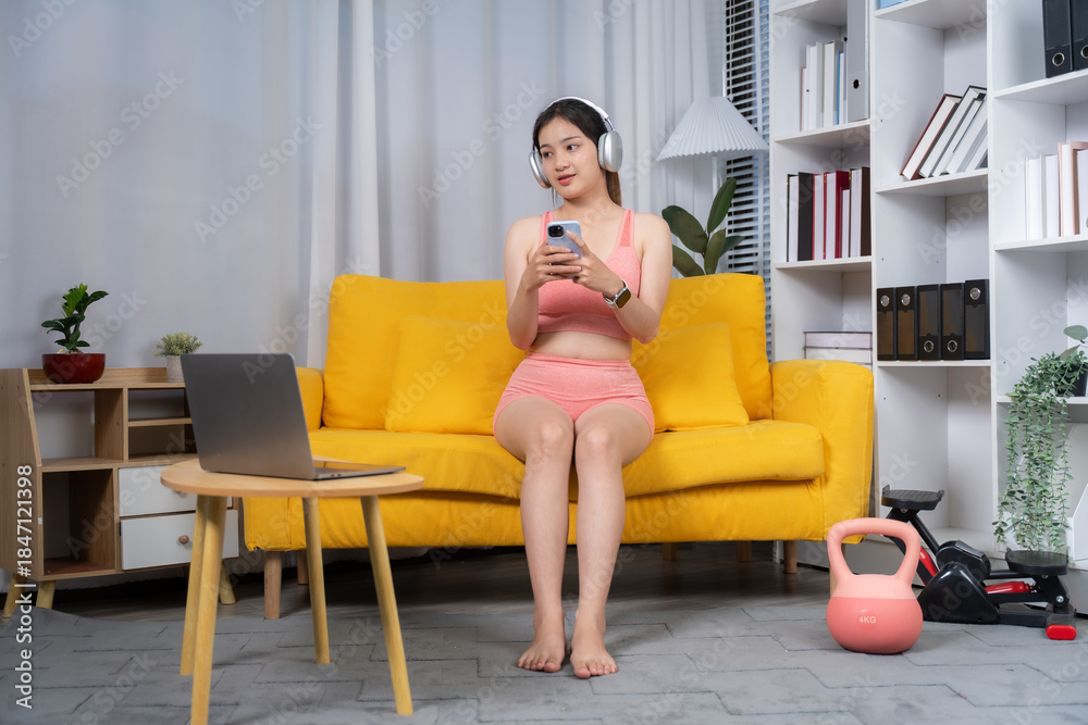 Obraz premium Well-being Wellness: A young woman sits relaxed with modern devices on a sofa at home, immersing herself in a peaceful and content state of wellness.