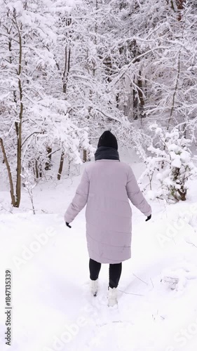 Woman exploring snowy forest in winter