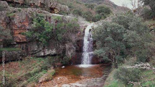 Tranquil waterfall in serene mountain landscape