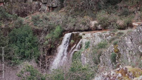 Serene waterfall nestled in a lush mountain landscape