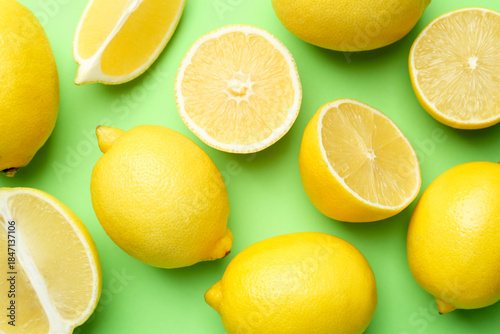 Foto Fresh ripe lemons on light green background, flat lay