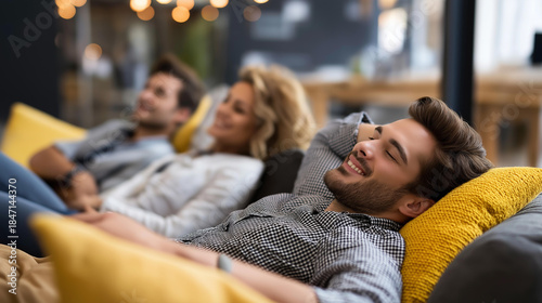 Millennials relaxing in modern lounge area, leisure time after work, cushioned seating, casual workplace culture, laughing and unwinding, contemporary office space, with copy space