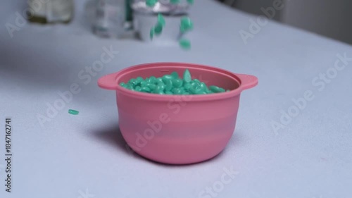 Wax granules for depilation are poured 