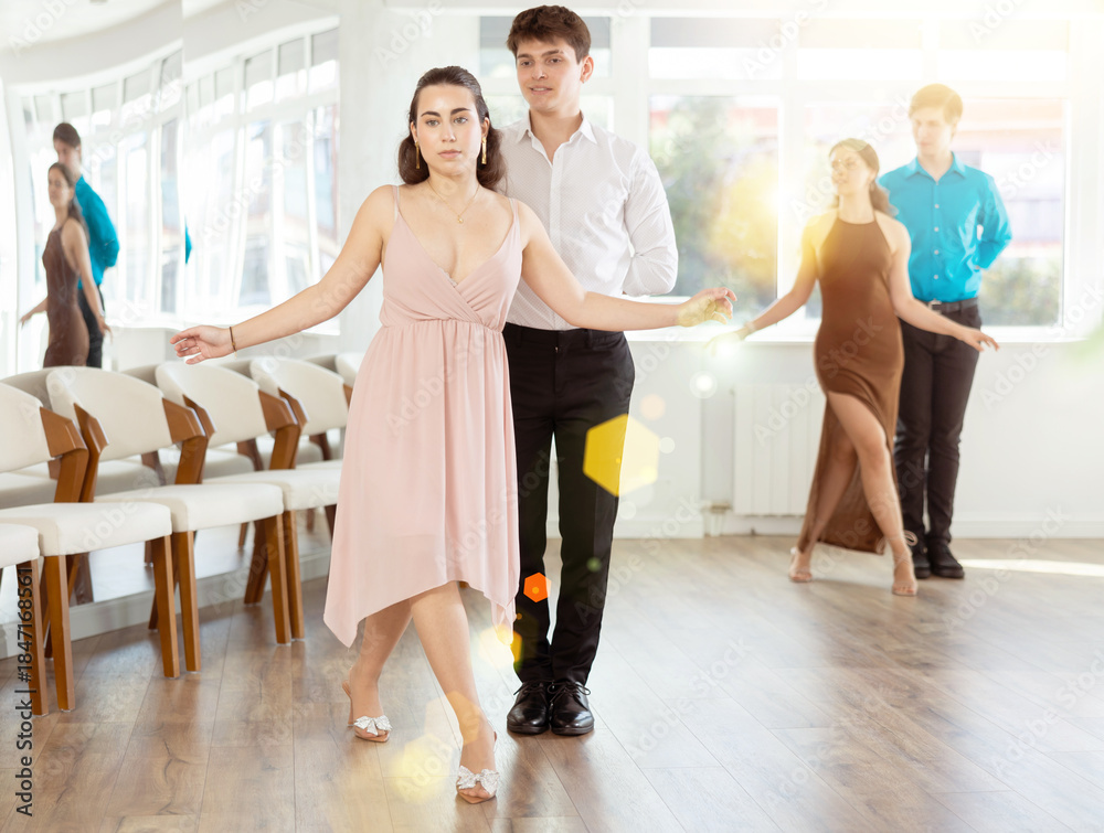 Fototapeta premium Happy girls paired with guys dance waltz in dance class