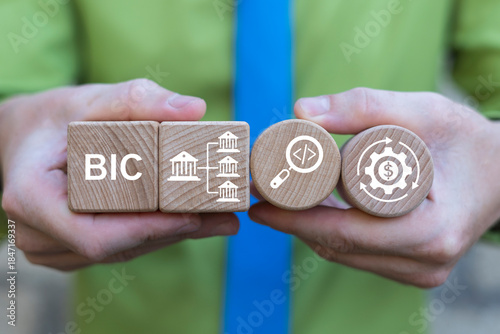Konstfotografi Business person holding wooden blocks with icons sees the abbreviation BIC