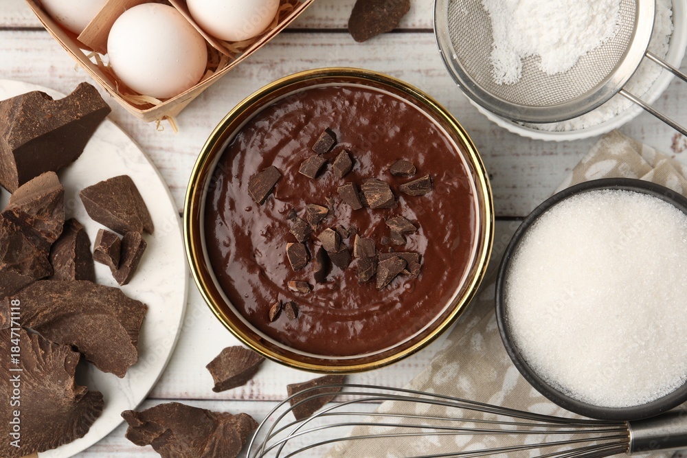 Obraz premium Ingredients for making muffins and whisk on white wooden table, flat lay