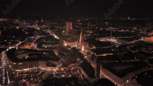 Wallpaper Mural Drone video at night offers cinematic view of Munich. Frauenkirche towers, the illuminated New Town Hall, and the bright Christmas tree standing above the bustling Christmas market in Altstadt Torontodigital.ca