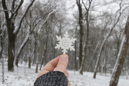 A hand is holding a large snowflake. Merry Christmas concept.